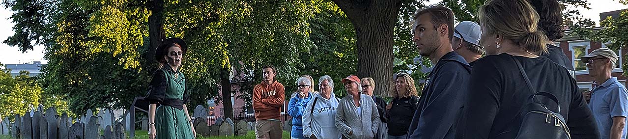 Ghosts & Gravestones Nightwalk tour guide and guests at burying ground