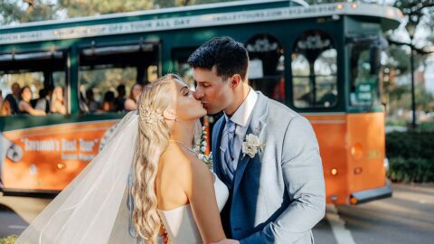 wedding couple in Savannah standing in front of trolley