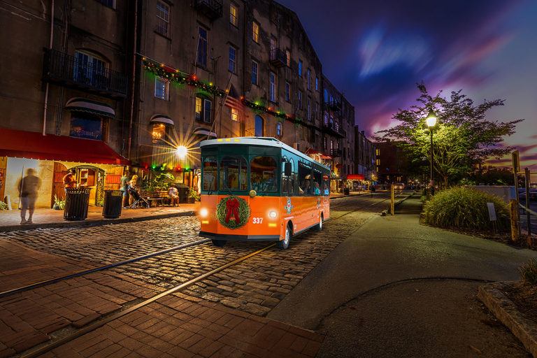 Savannah trolley driving past river street at night