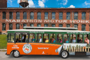 Old Town Trolley Tour passing in front of the old brick Marathon Automobile Company building