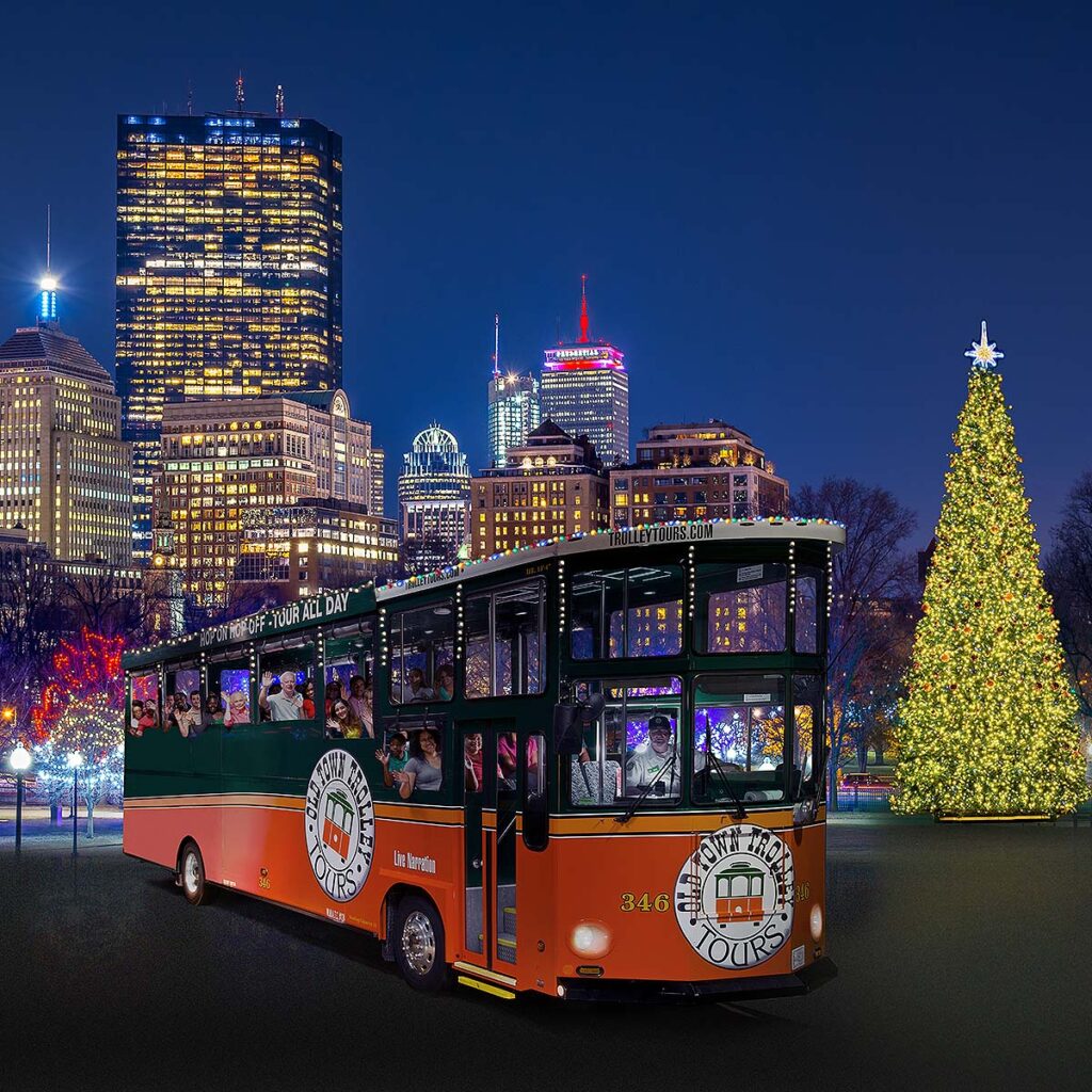 night time picture of trolley in front of Boston skyline and holiday lights