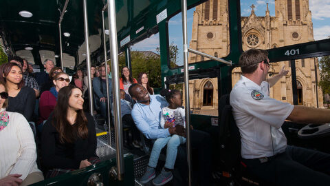 interior of San Antonio Old Town Trolley vehicle with guests looking out the window at San Fernando Cathedral