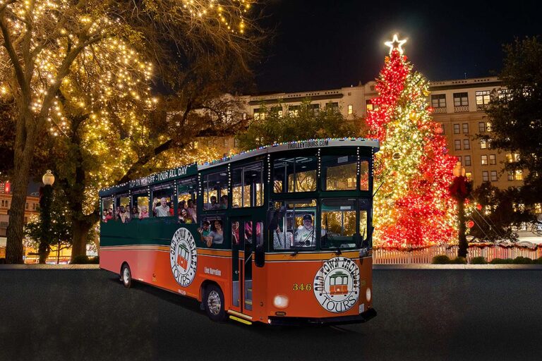 San Antonio holiday trolley surrounded by holiday lights and Christmas tree