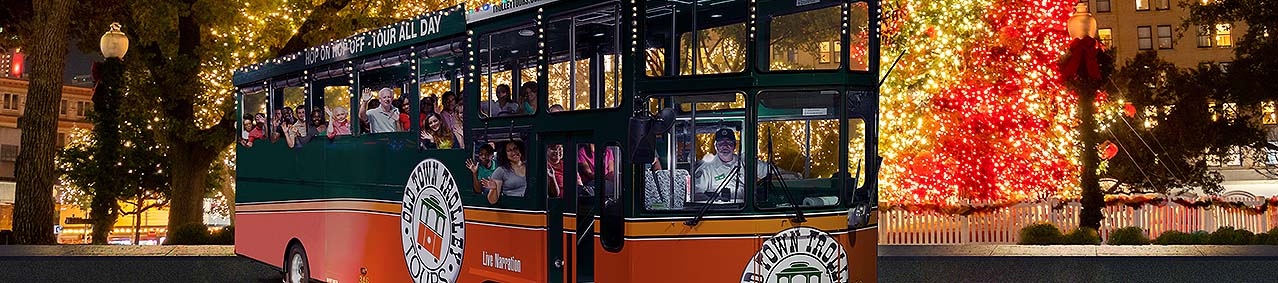 San Antonio holiday trolley surrounded by holiday lights and Christmas tree